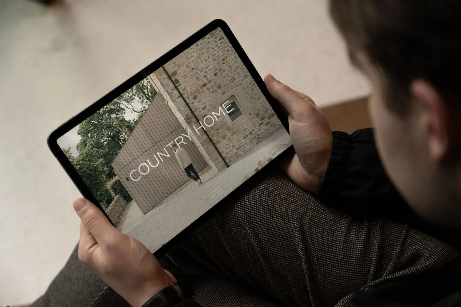 A hand holding a phone displaying a property overview screen from the Street.co.uk app.