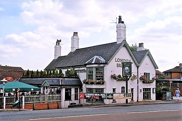 The London Grill pub, a white-painted building with dark roof and multiple chimneys, viewed from the street