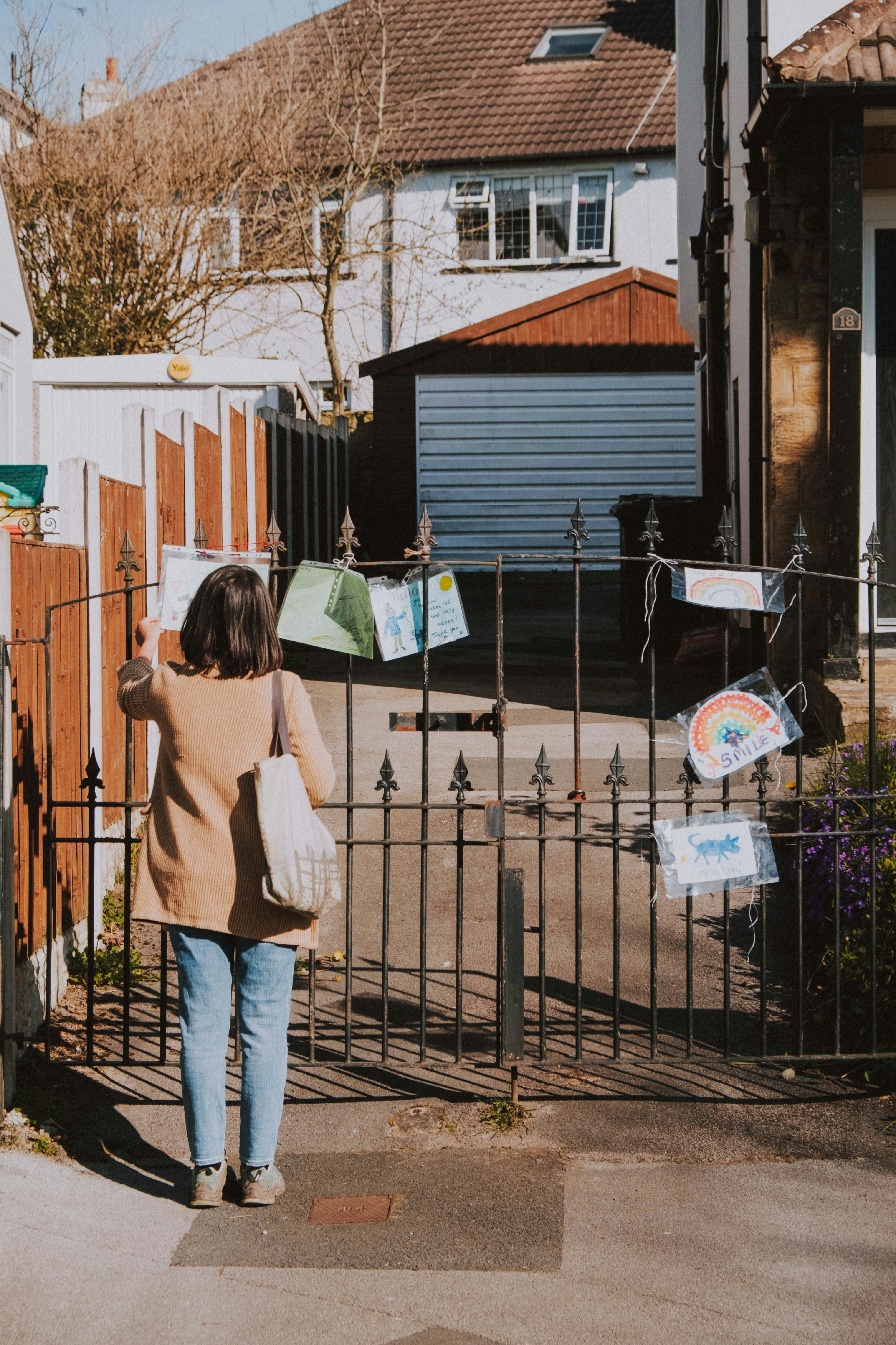 Woman with shopping bags at house gate, lifestyle moment
