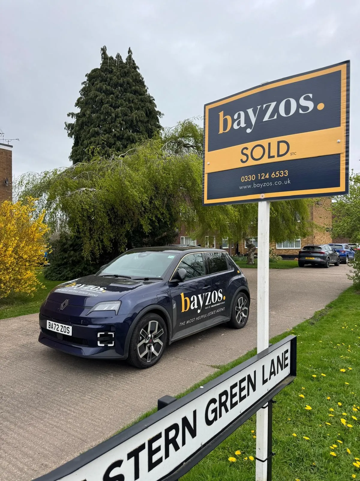 bayzos sold board in front of a bayzos estate agent branded car