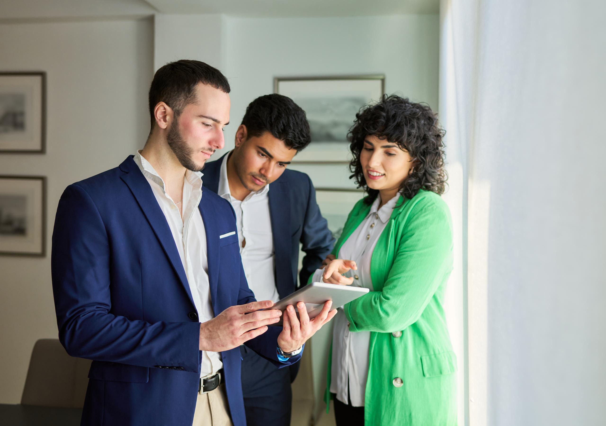 Estate agents stand over an iPad