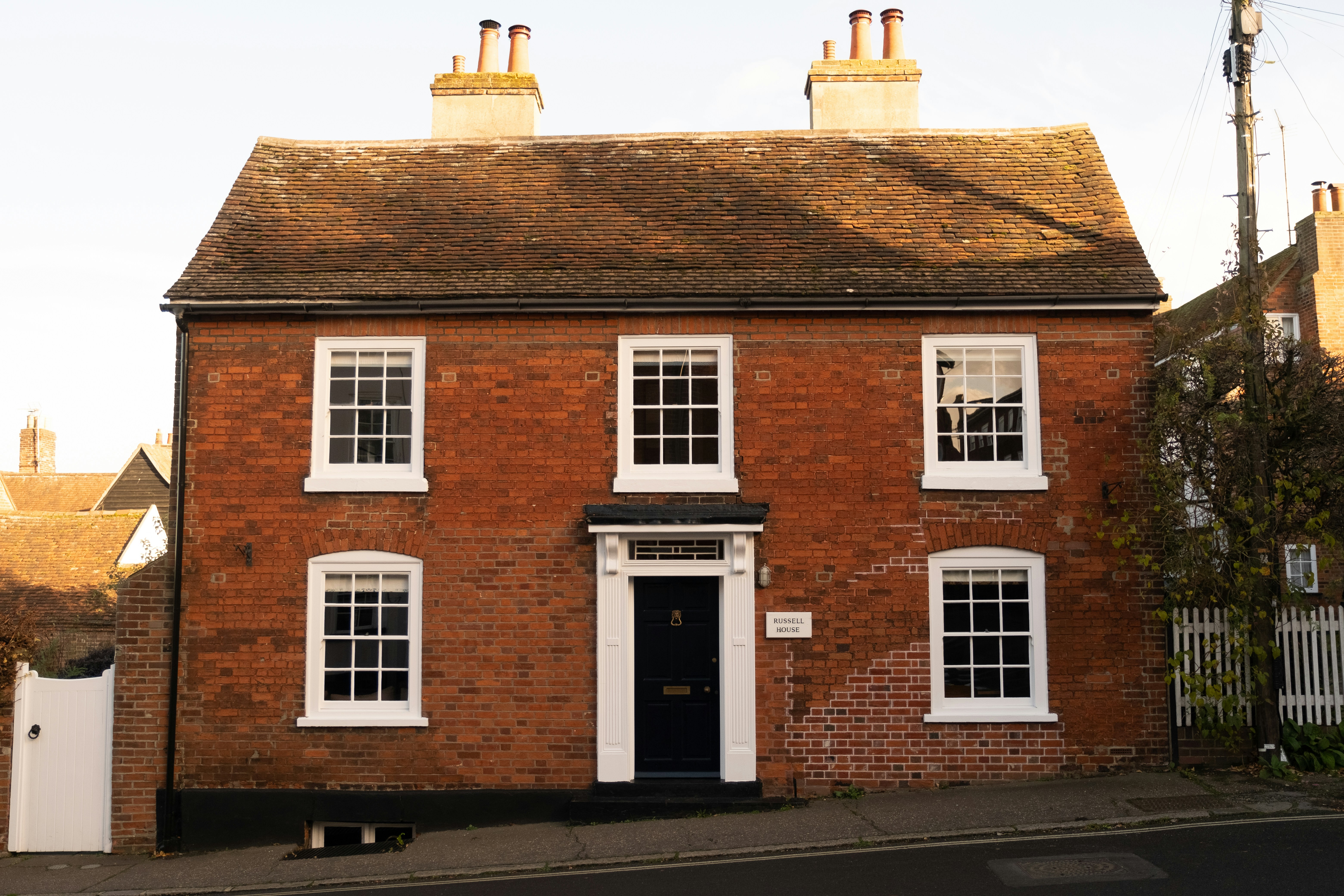 Red brick UK property exterior with white windows and black door