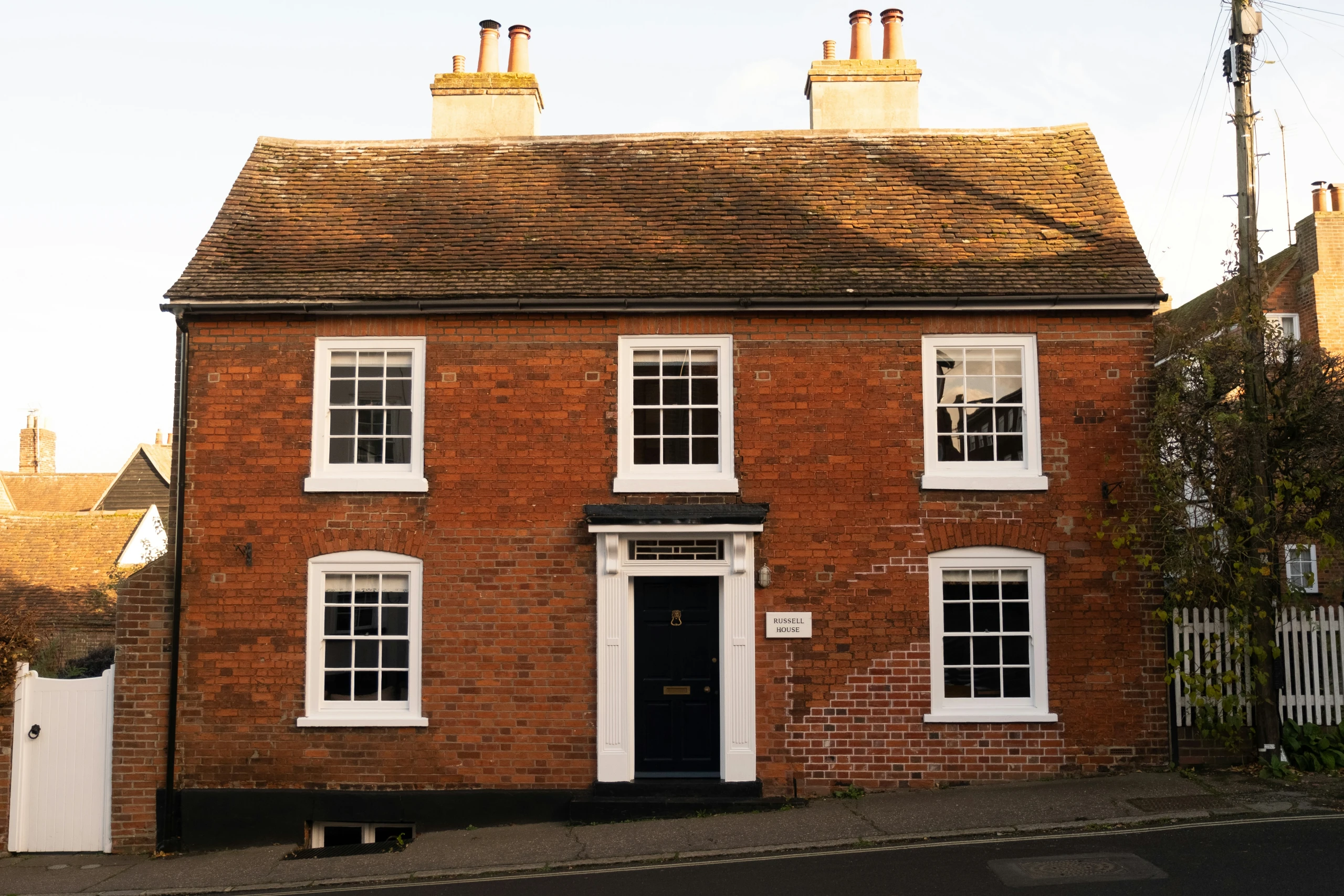 Red brick UK property exterior with white windows and black door