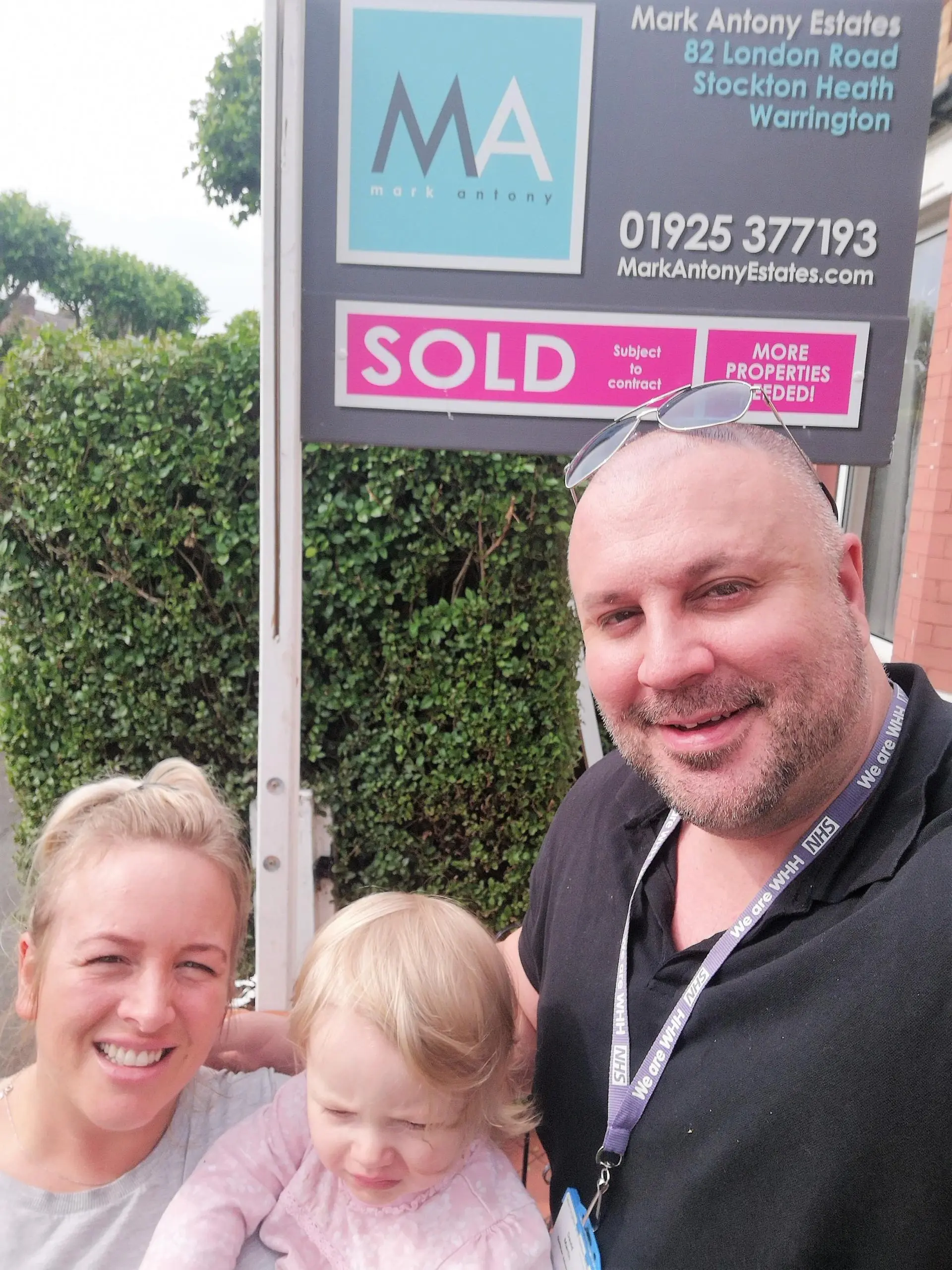 Three people posing in front of a Mark Antony Estates property board displaying "SOLD Subject to contract"
