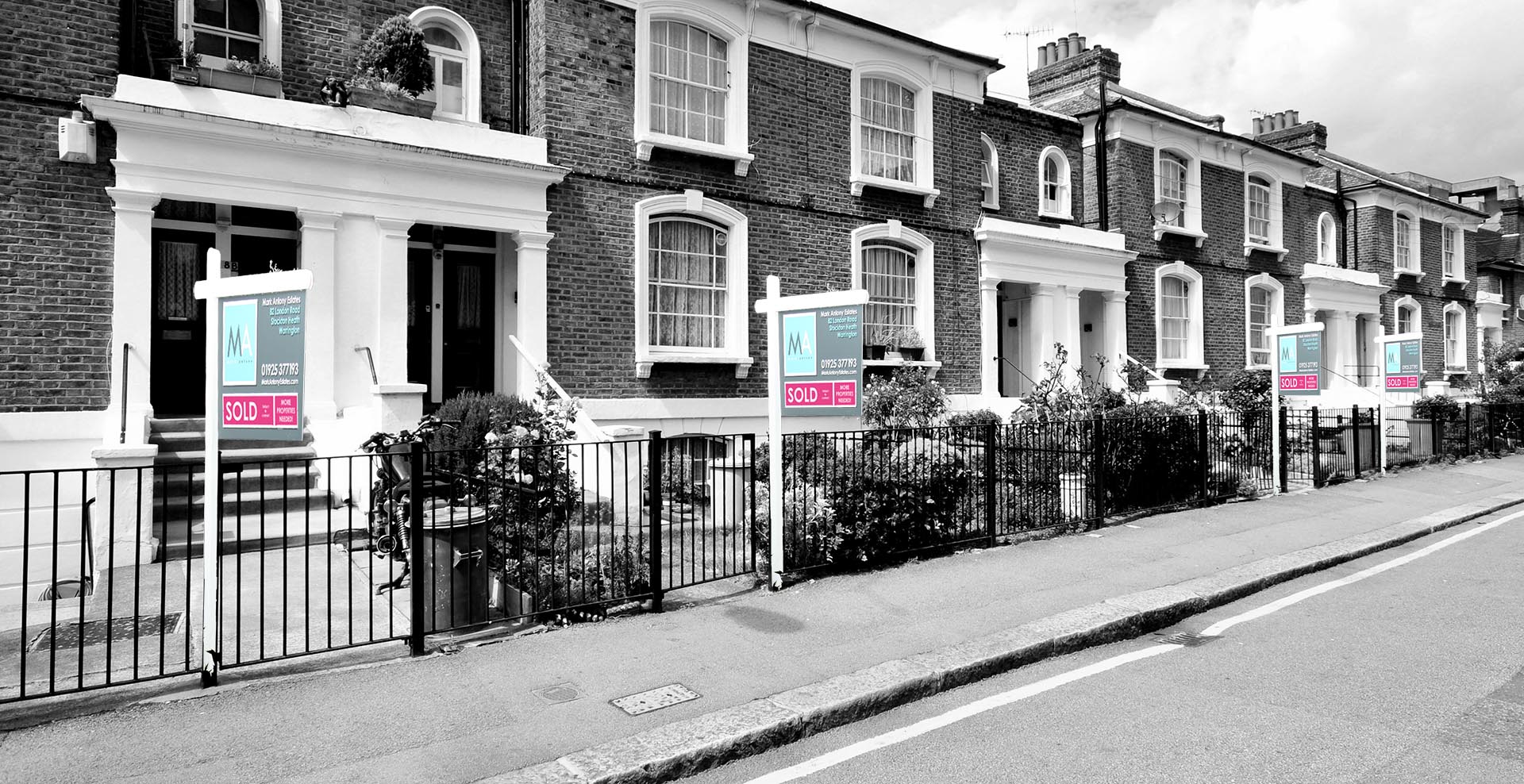 black and white image of a street with lots of sold boards sold by mark antony estates