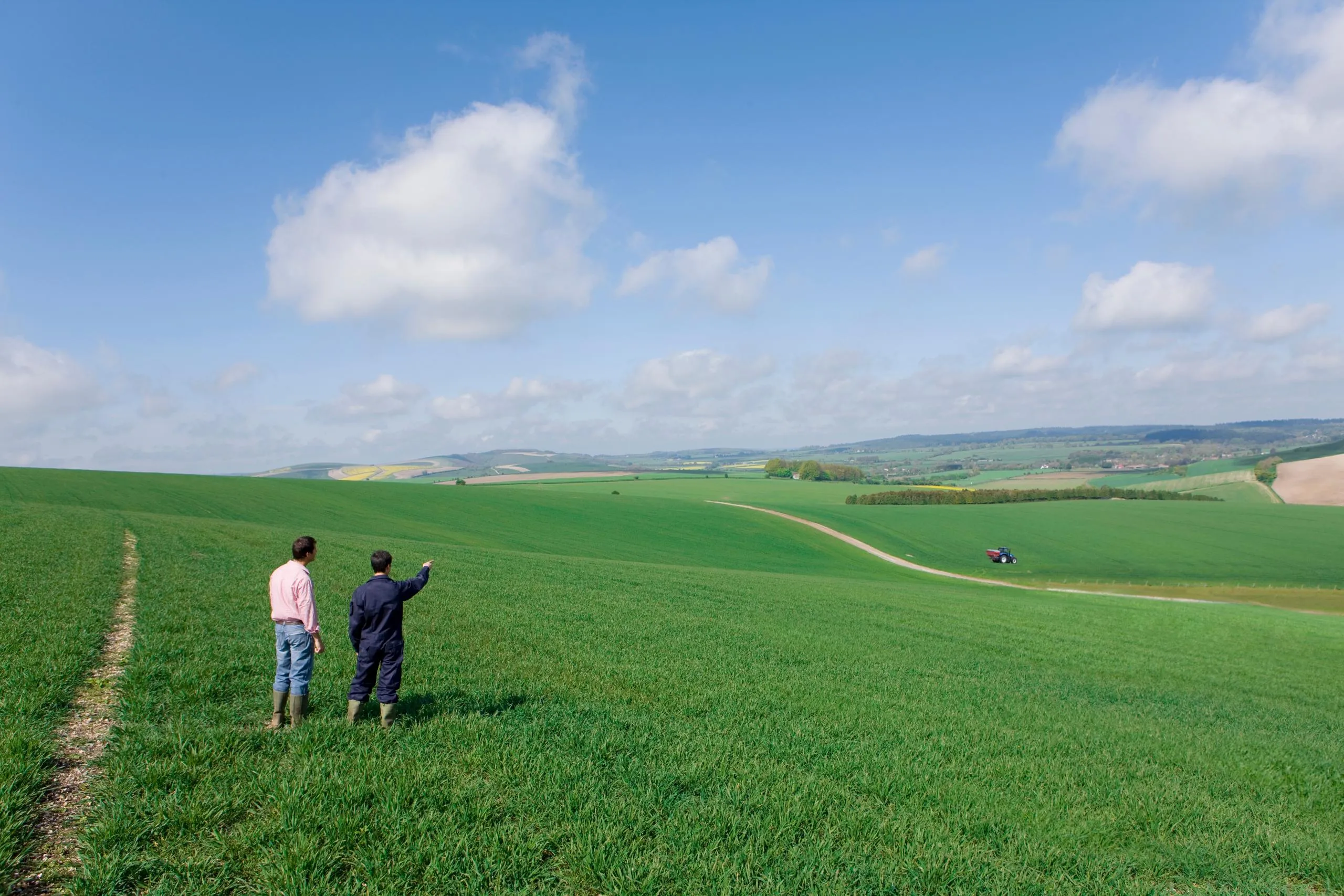 A rural land surveyor standing in a field