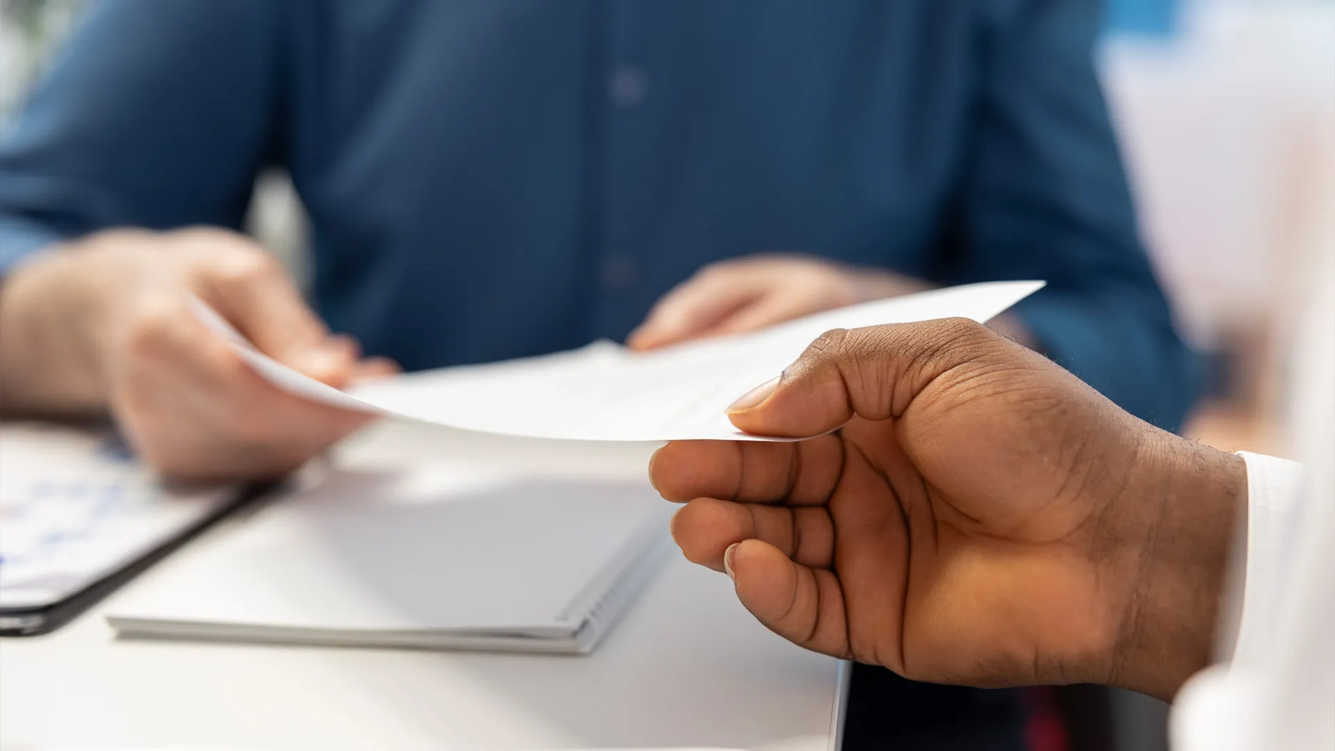 Someone handing a document to another person