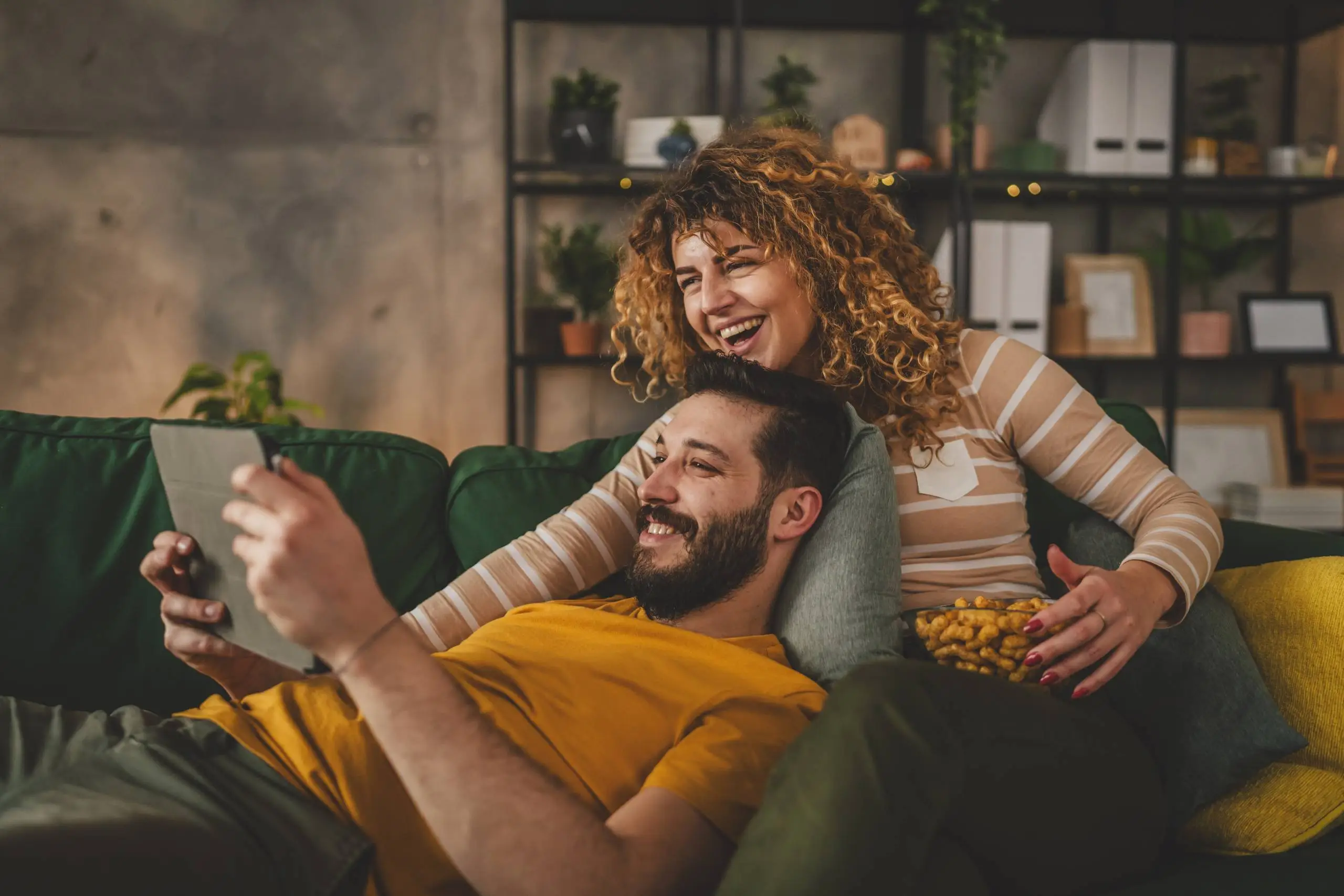 A man and a woman on the sofa looking at an iPad
