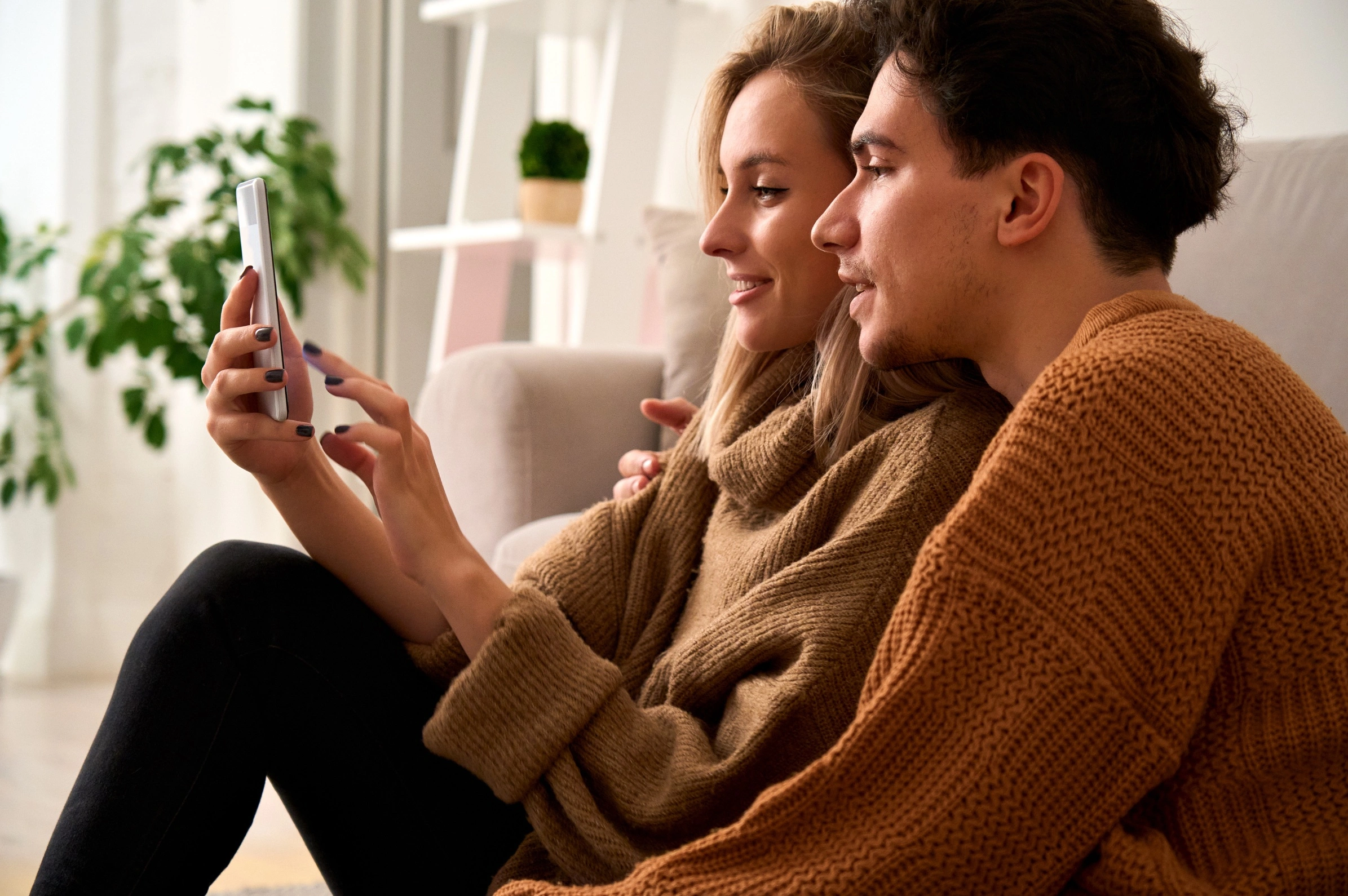 A young man and woman looking at a mobile phone