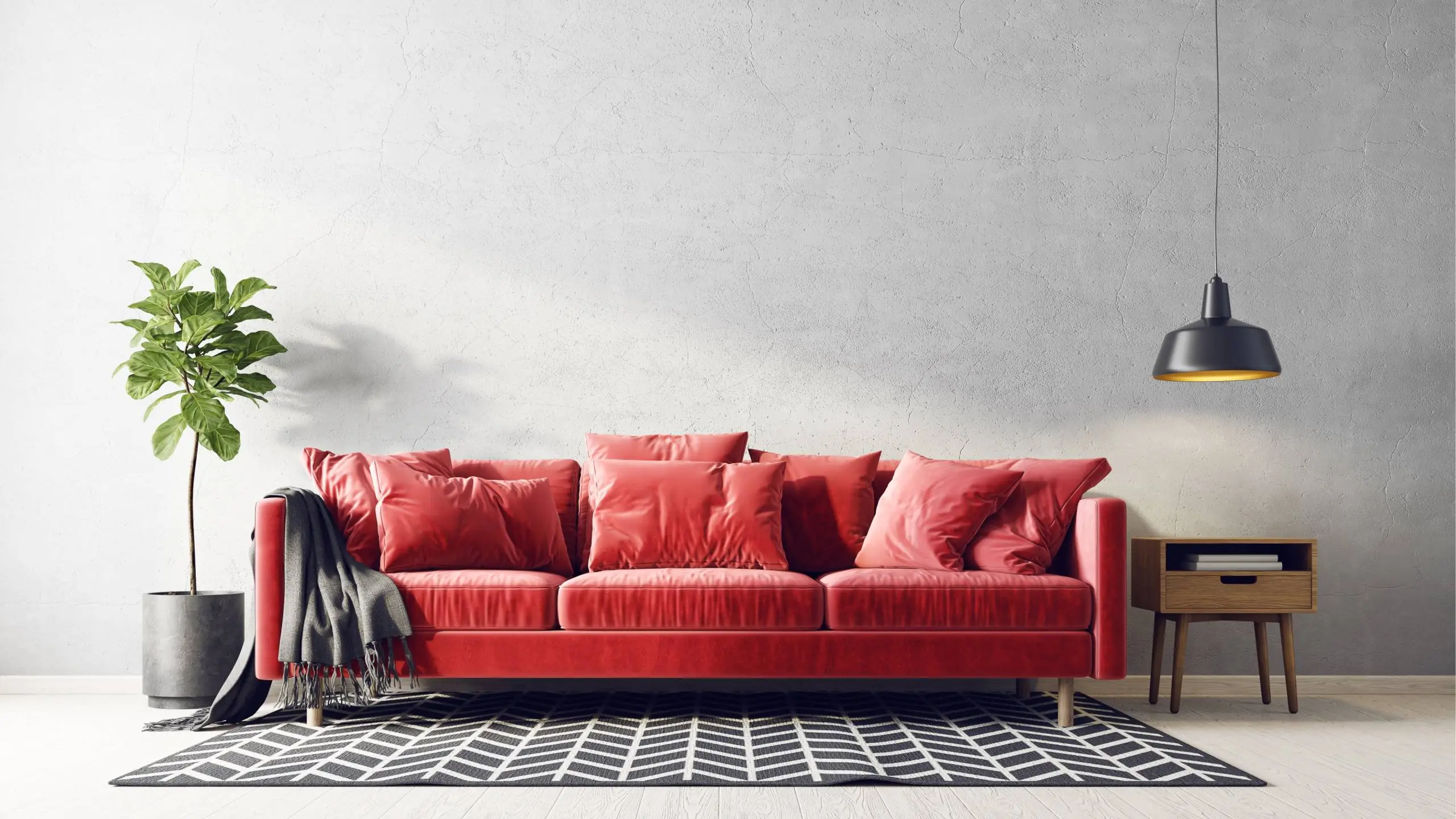 A red sofa with a plant and lamp to the side