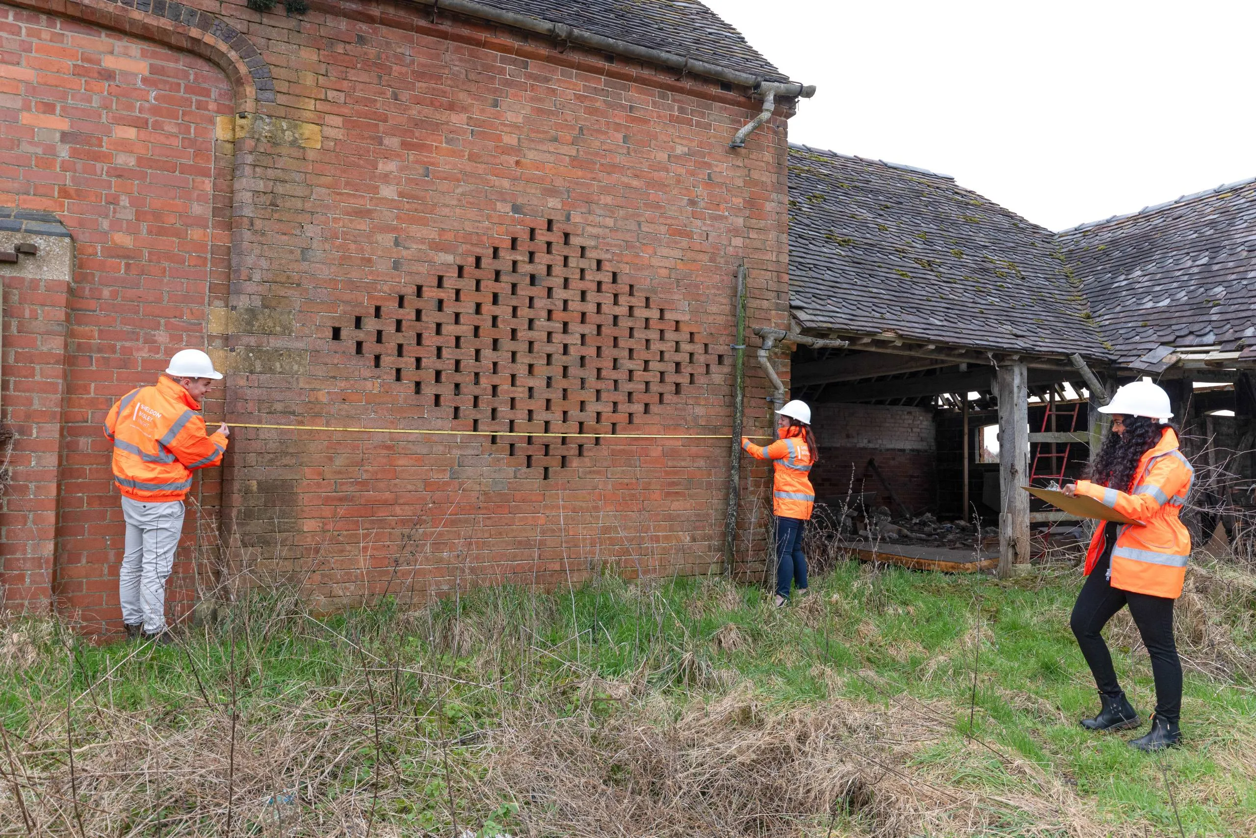 Two planners measure the site of a property