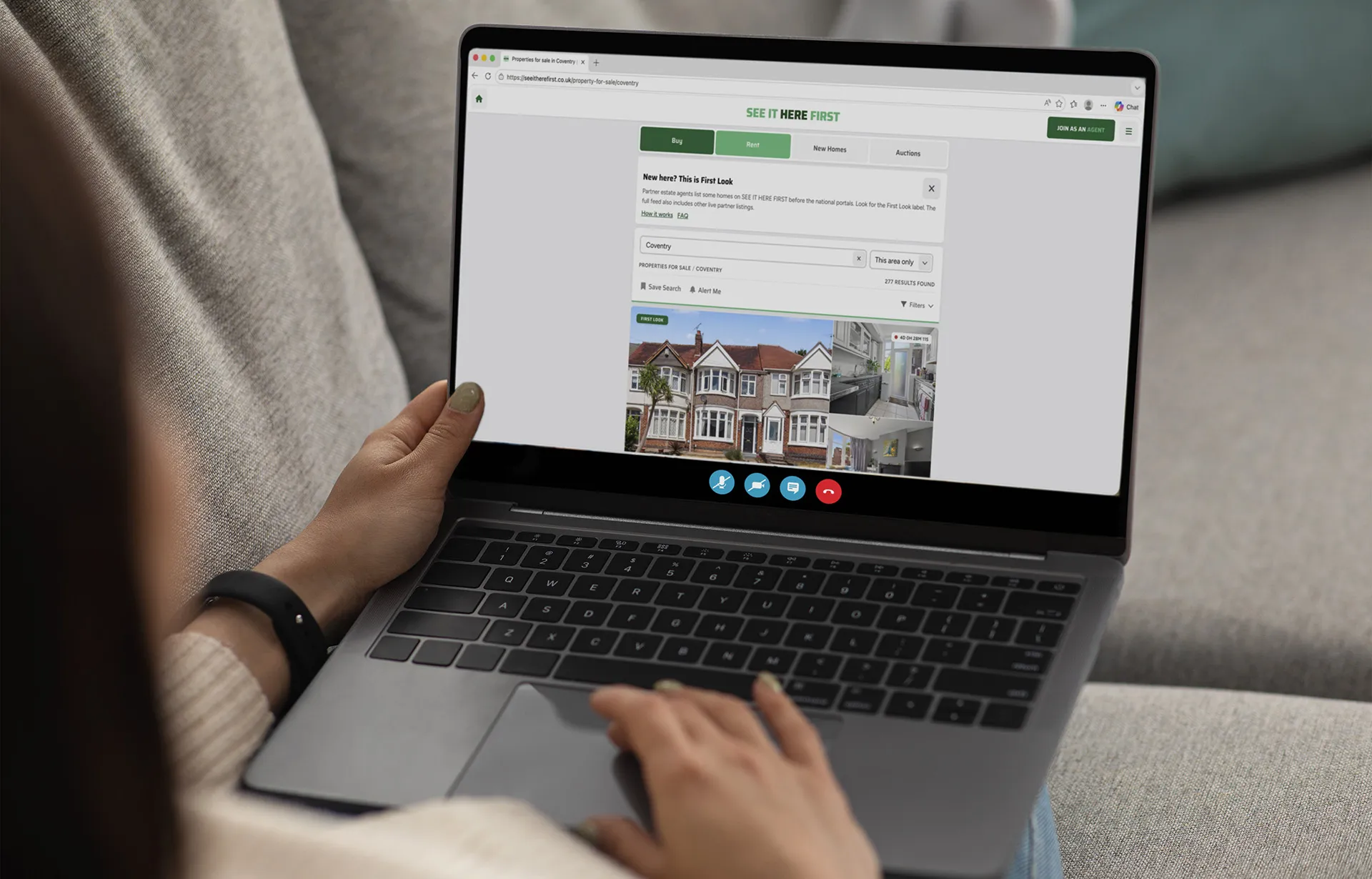 A laptop screen shows someone browsing the See It Here First website