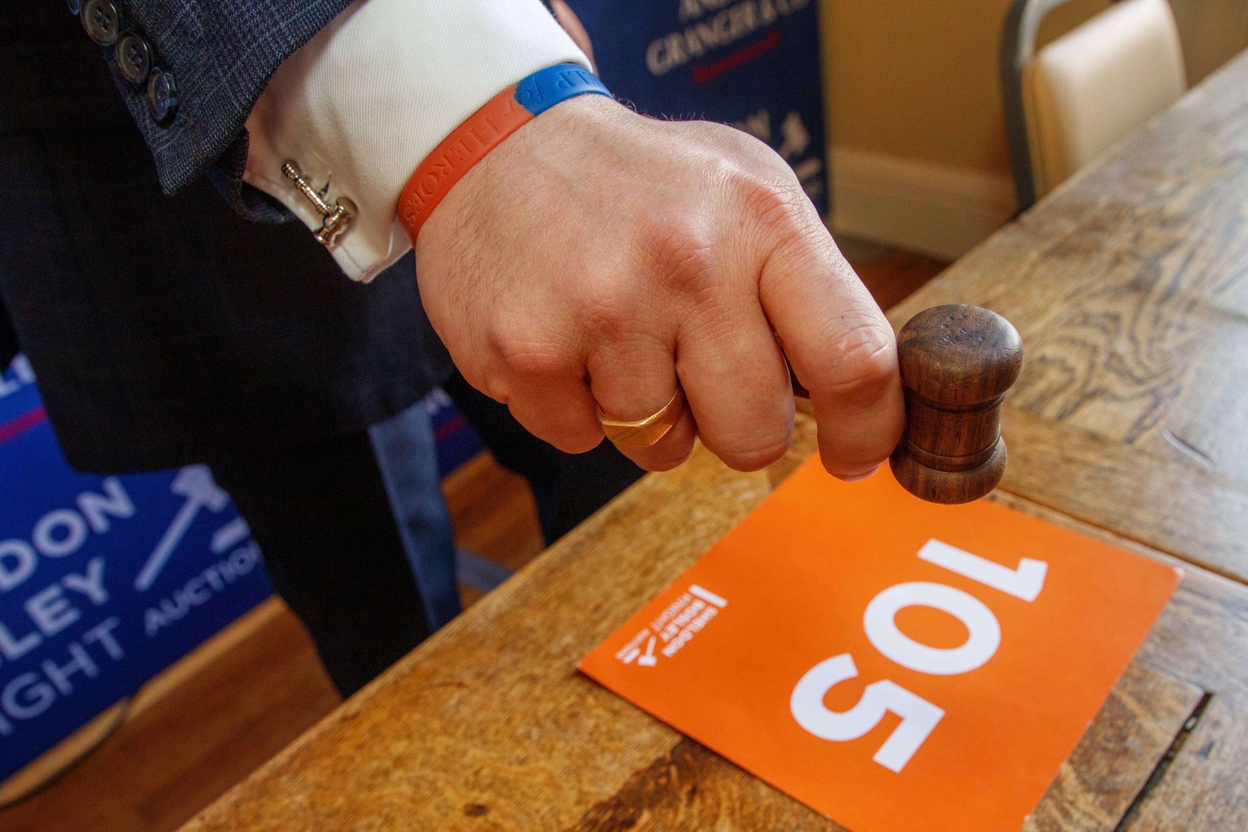 A hand brings a gavel down at a Sheldon Bosley Knight property auction