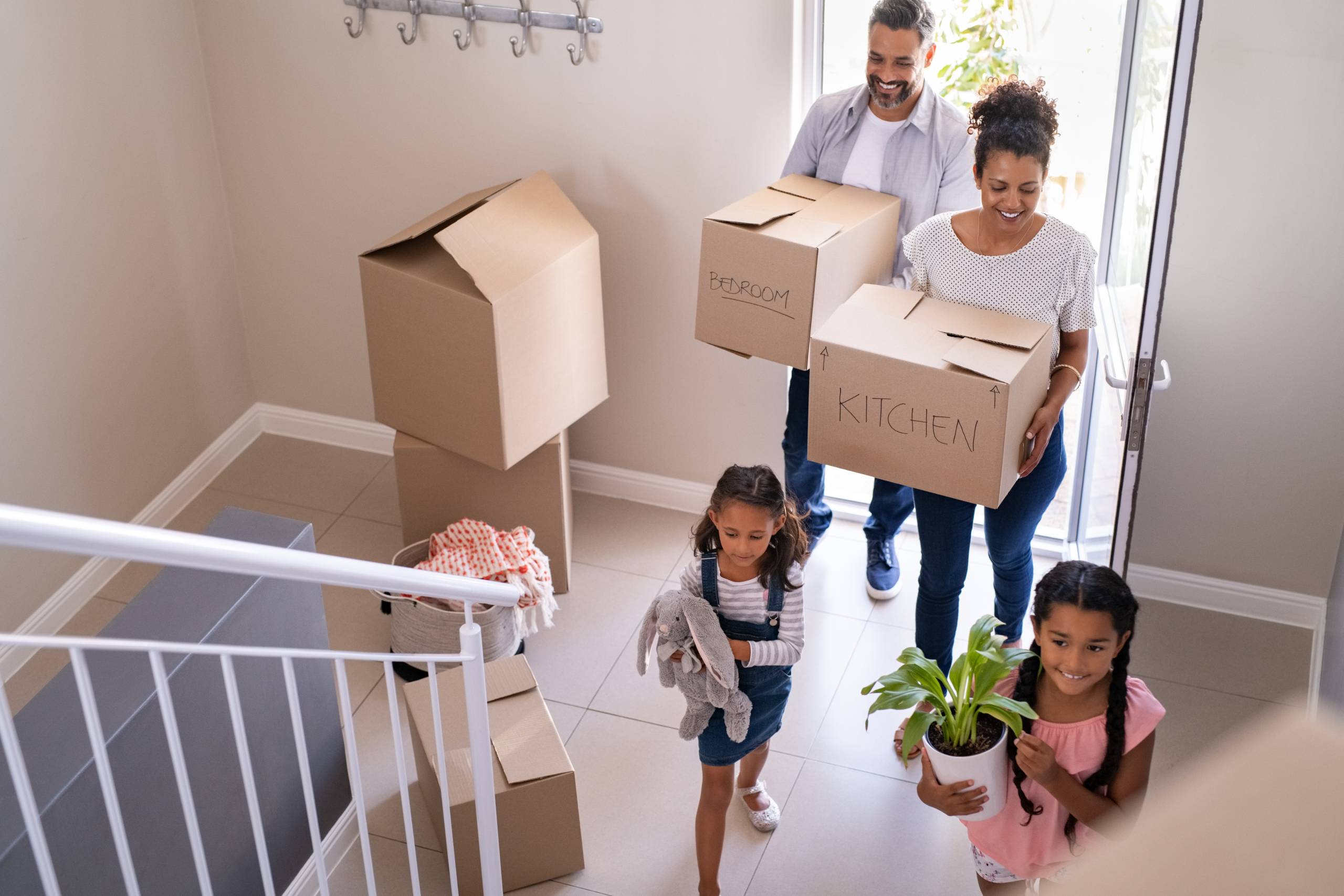 A family carry moving boxes