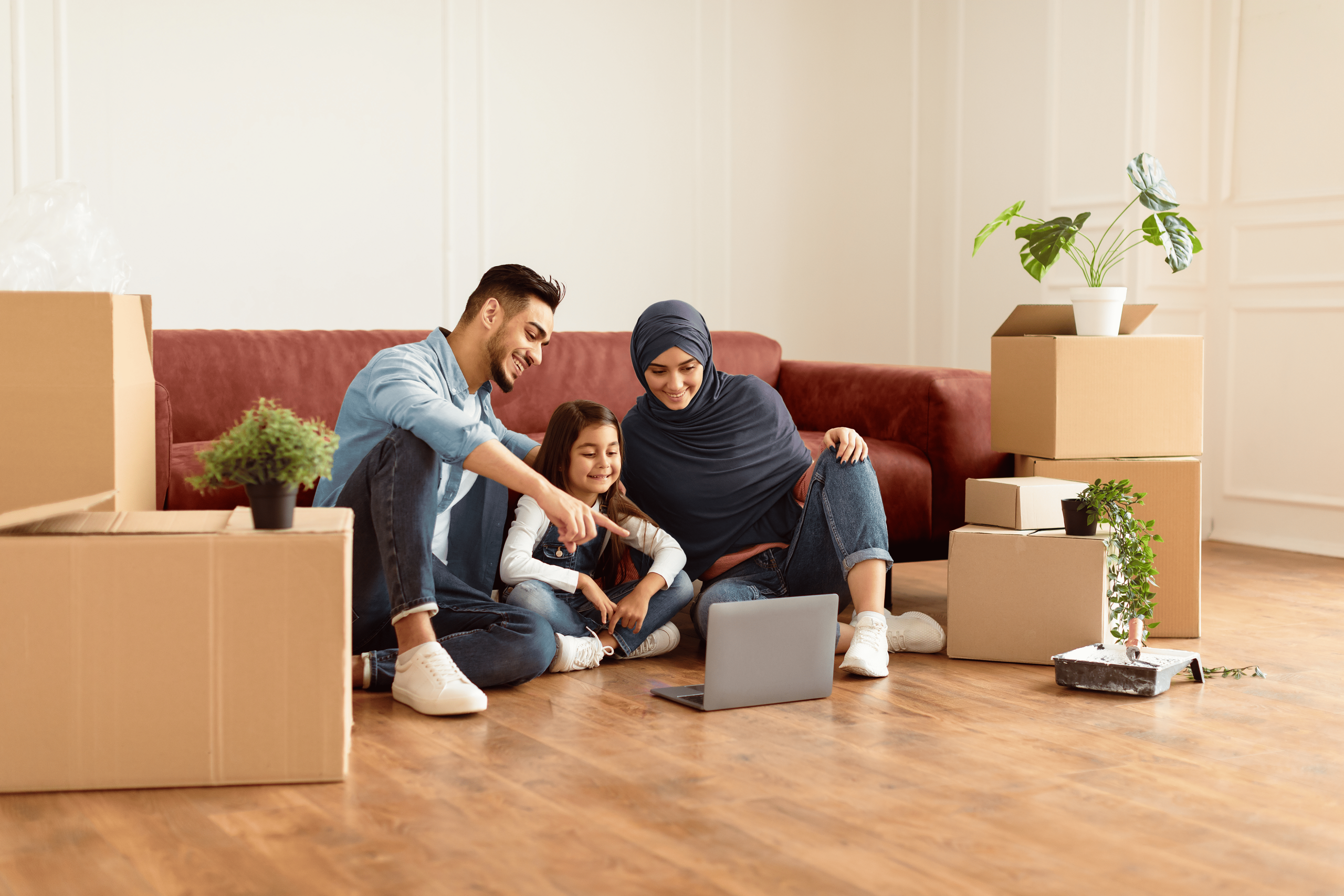 An international family sit in their new home surrounded by moving boxes