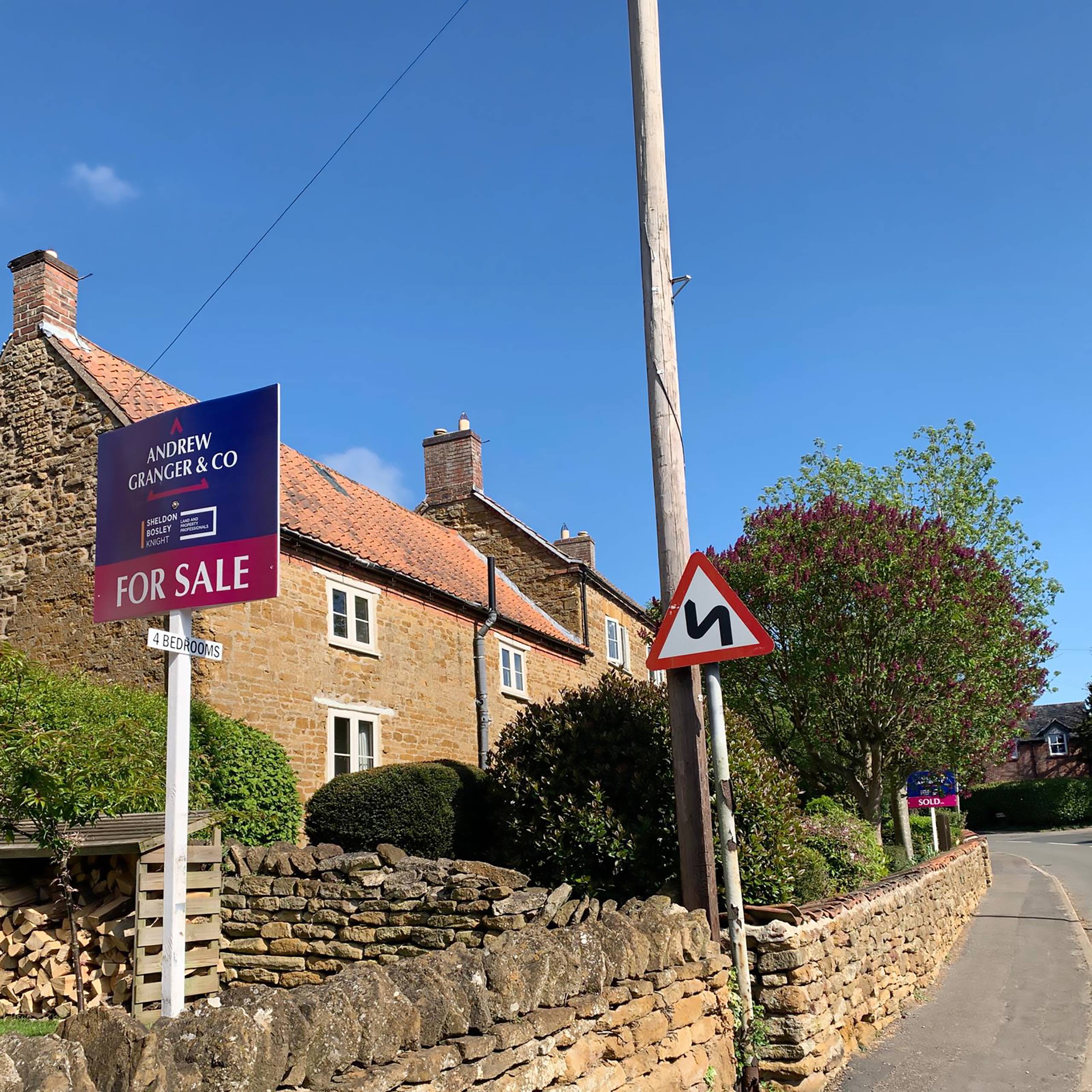 An Andrew Granger For Sale board outside a stone cottage in Leicestershire