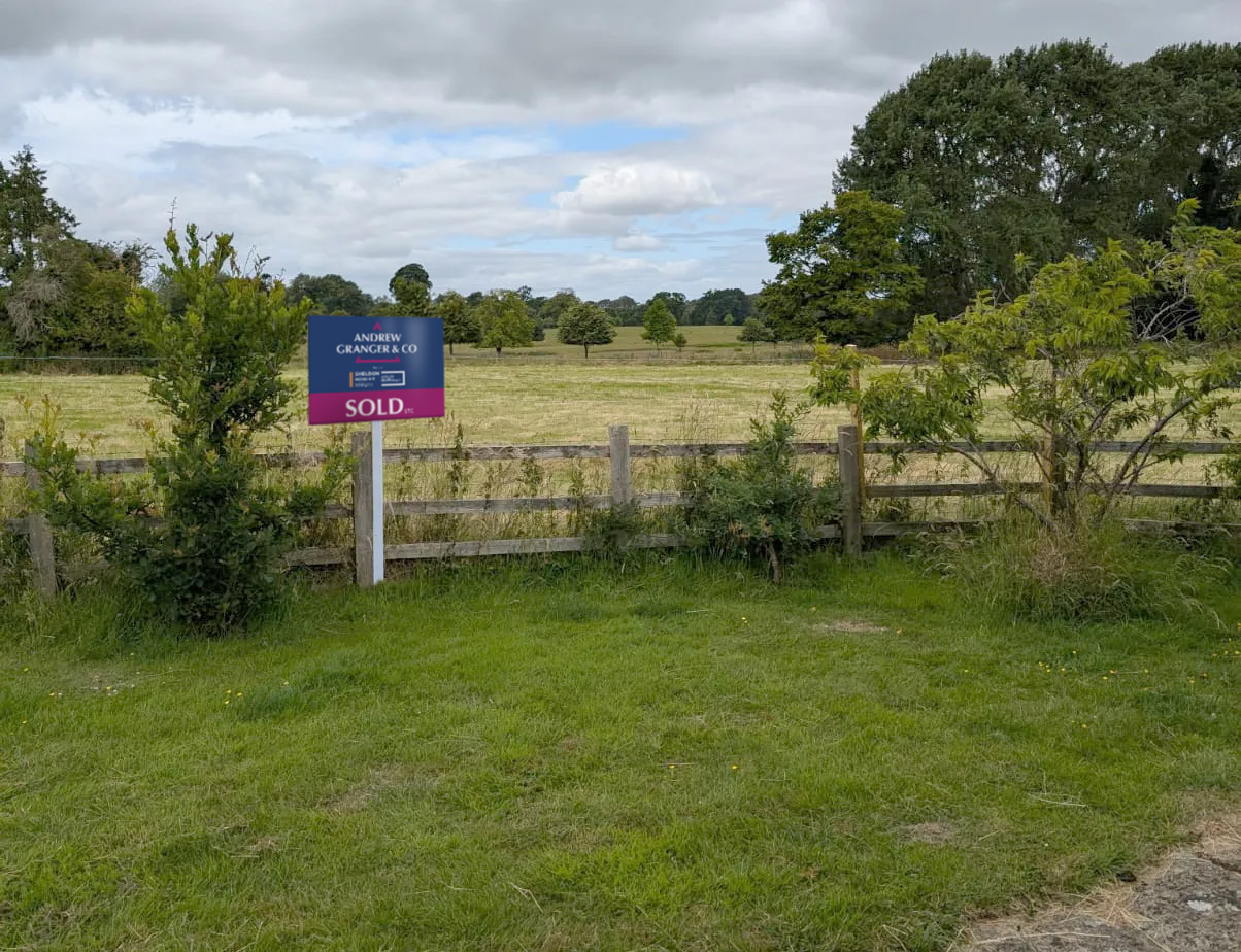 An Andrew Granger & Co sold board sits on a field