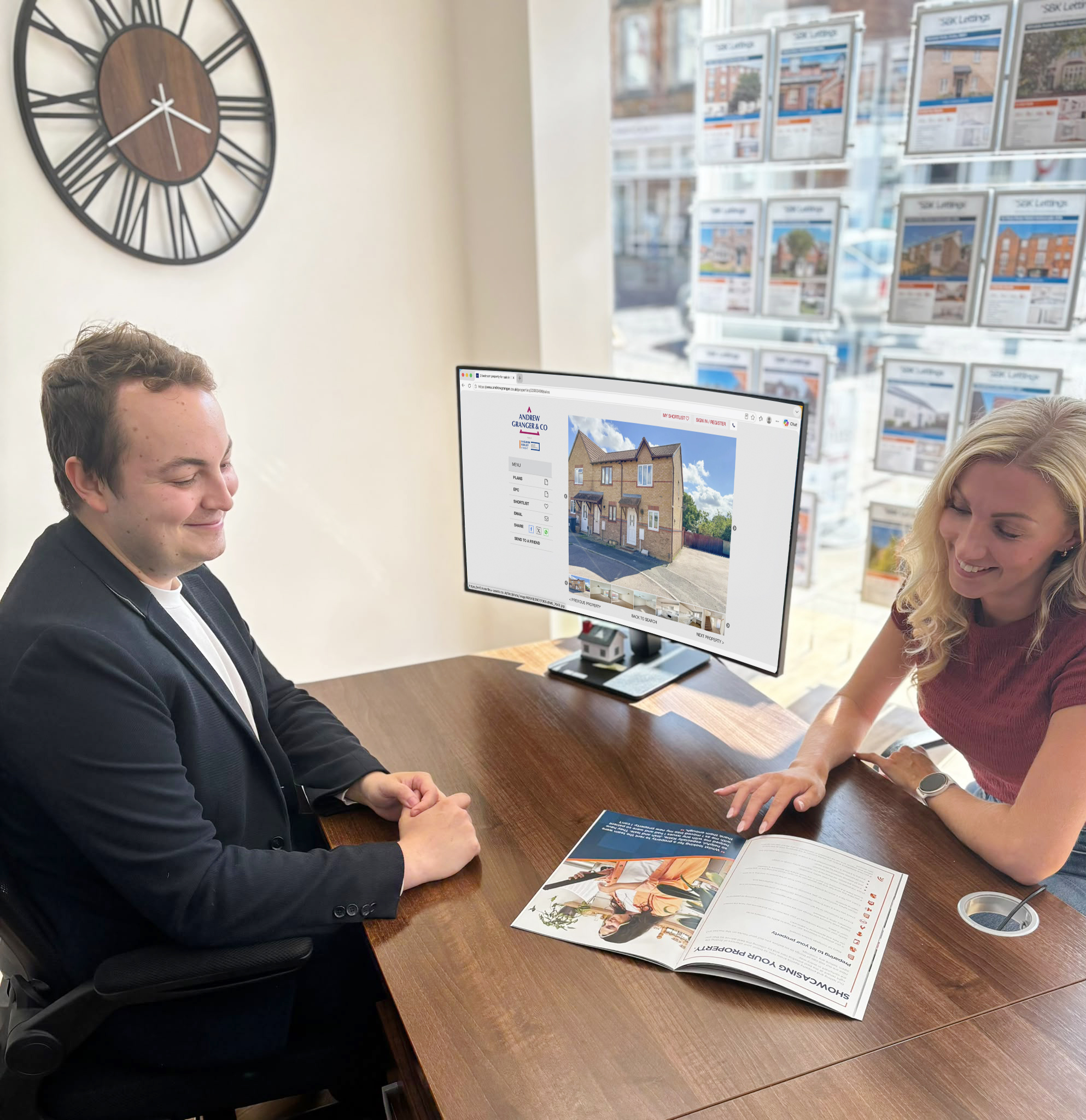 An estate agent at Andrew Granger shows a customer through the sales brochure