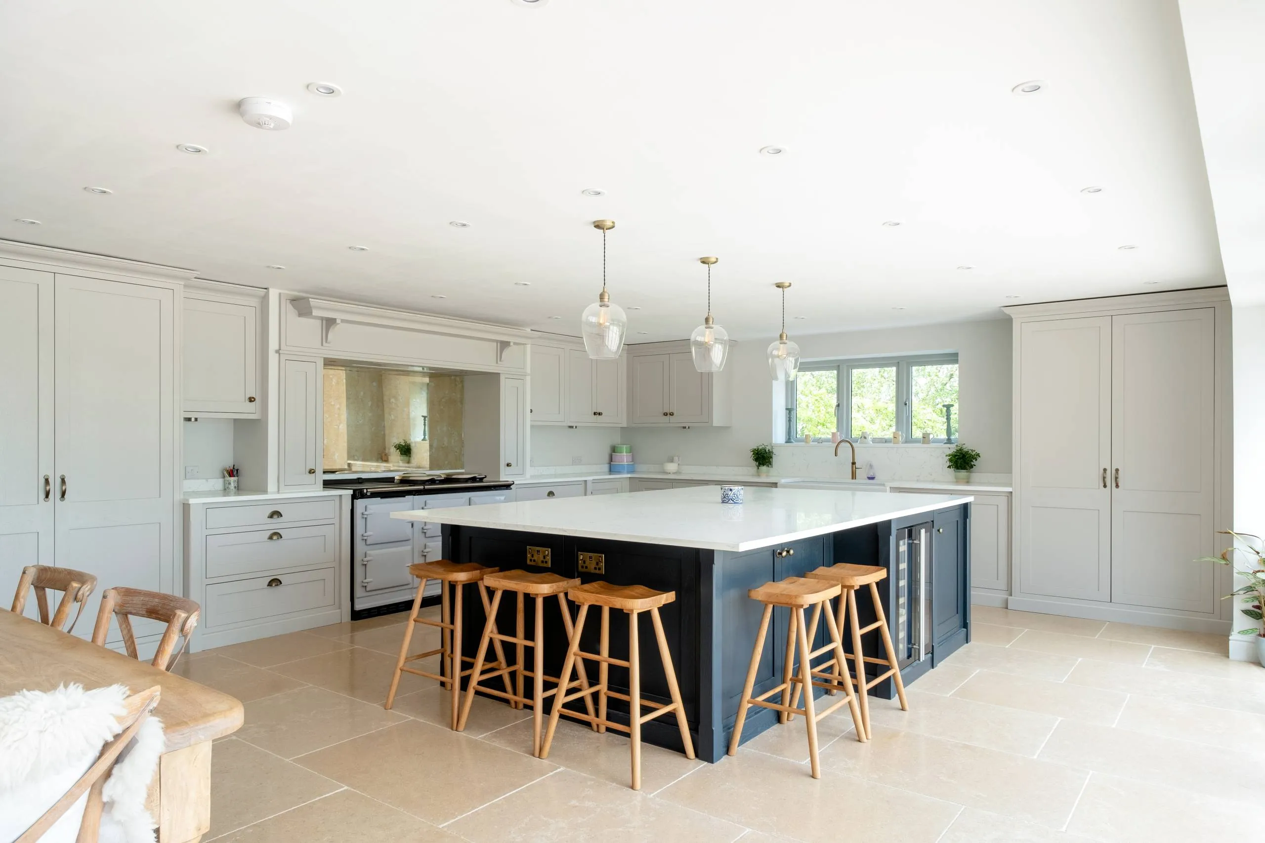 Luxury bespoke kitchen with large central island, navy cabinetry and pendant lighting