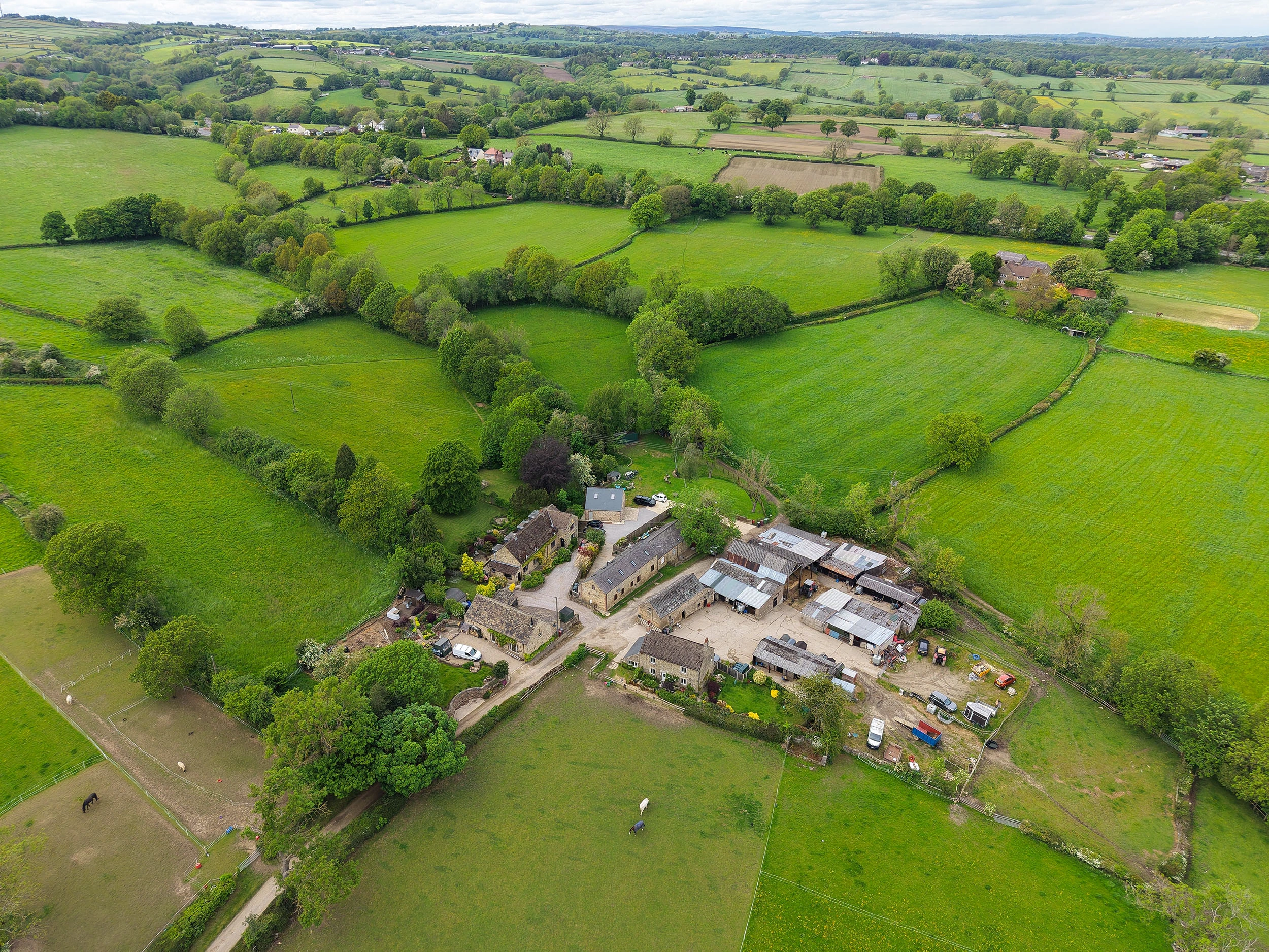 An aerial drone image of a farmhouse with land