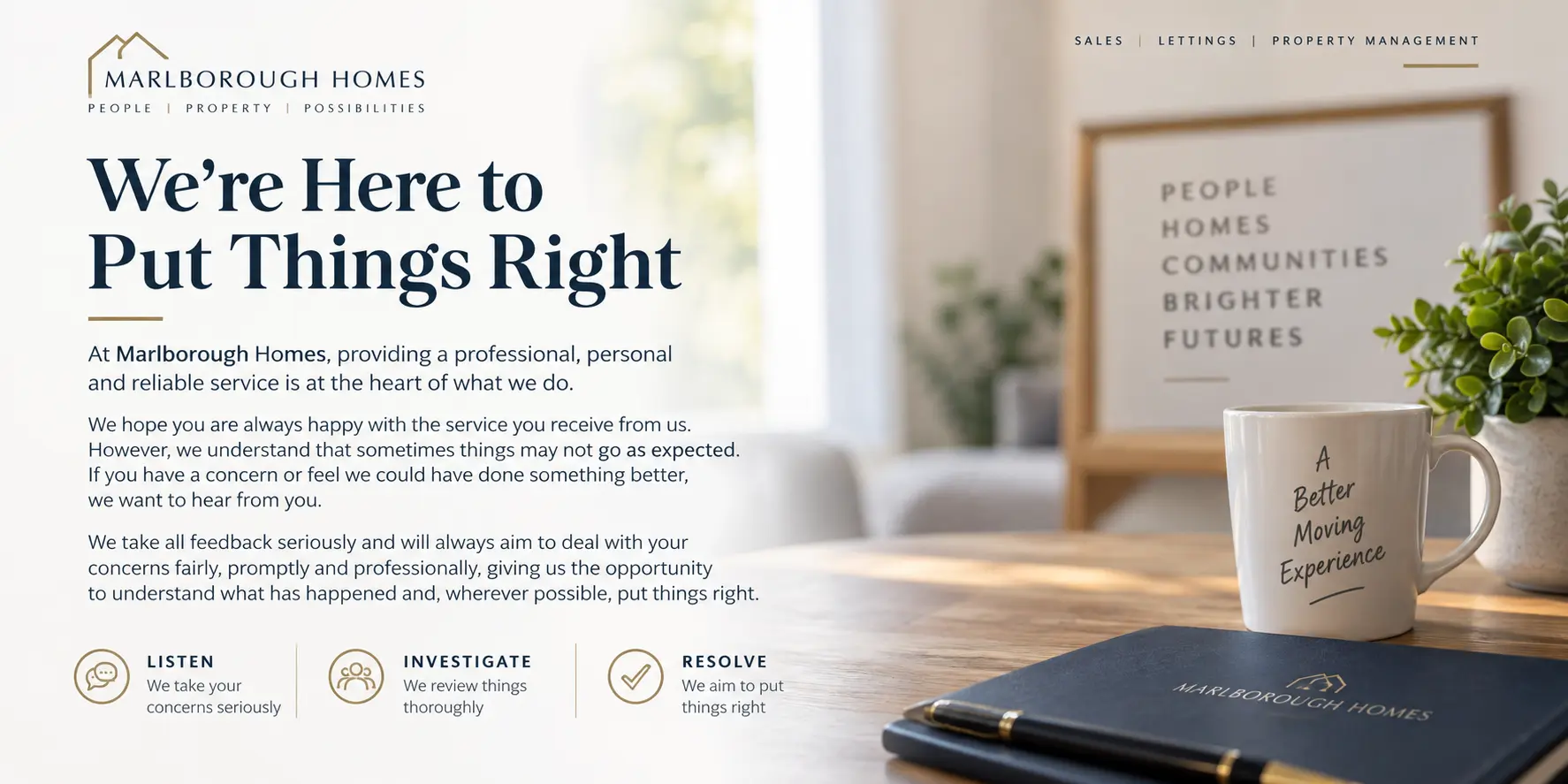 Office desk with white mug reading "A Better Moving Experience", framed sign with text, potted plant, and black notebook branded "Marlborough Homes"