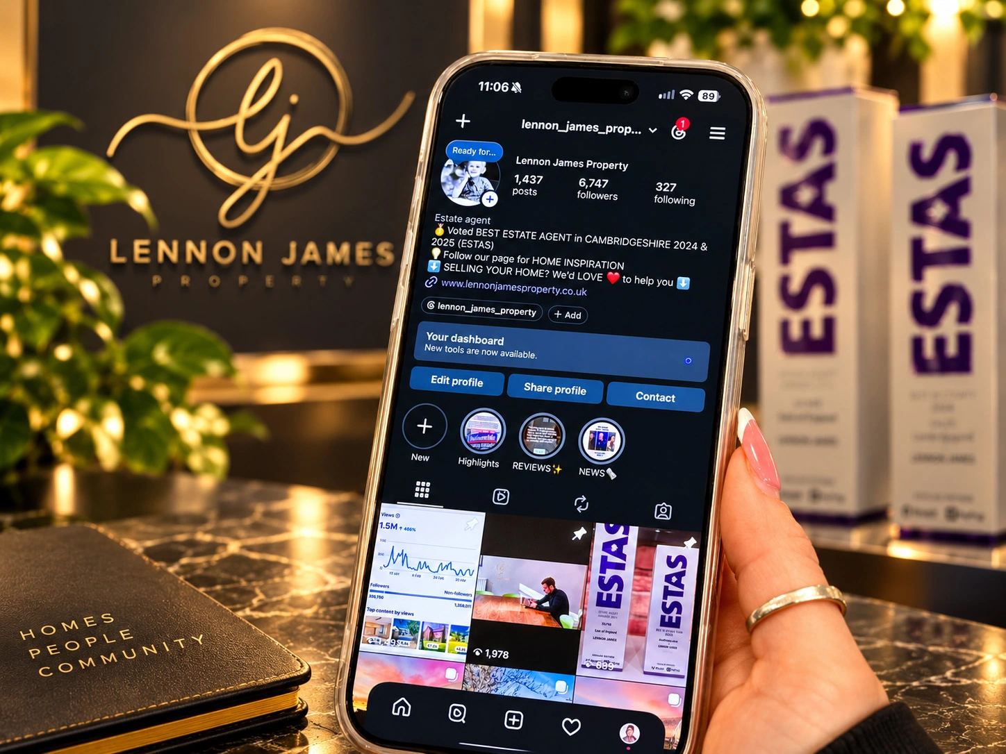 Smartphone displaying Lennon James Property Instagram profile with 1,437 posts and 6,747 followers, held in front of branded signage and notebook