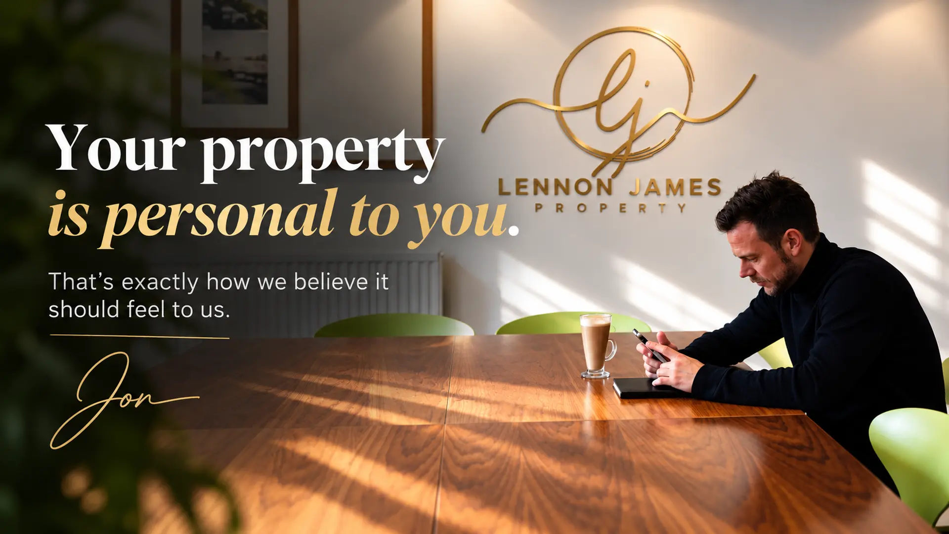 Man in dark jacket seated at wooden table with coffee cup and phone, Lennon James Property branding and tagline "Your property is personal to you"