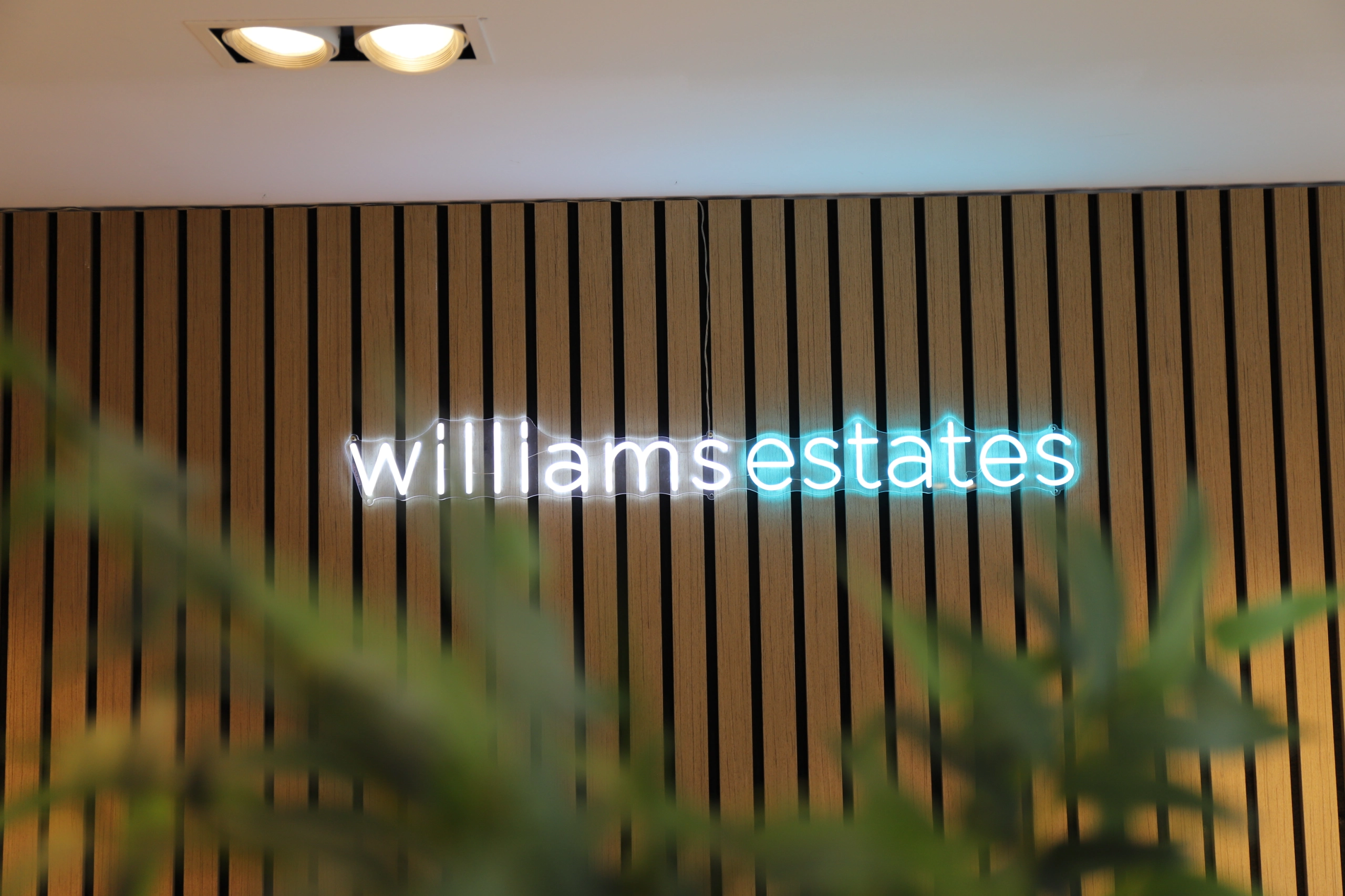 Williams Estates sign in neon supporting a Williams Estates Commecial background