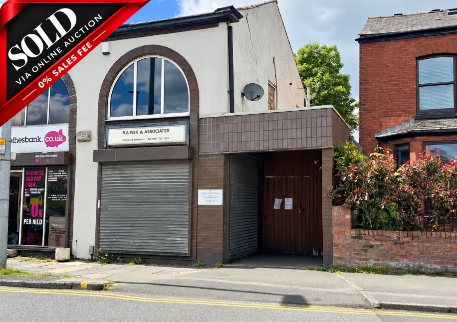 Terraced commercial building with sold via online auction banner, arched window, and RA Fish & Associates signage. Adjacent red brick building visible on right.