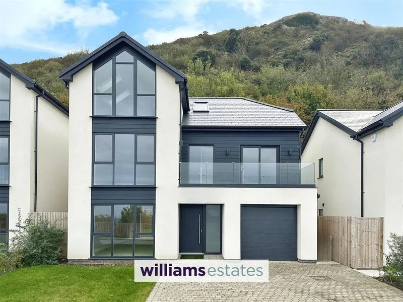 Saffron property exterior showing driveway, integral garage, and balcony with hillside views