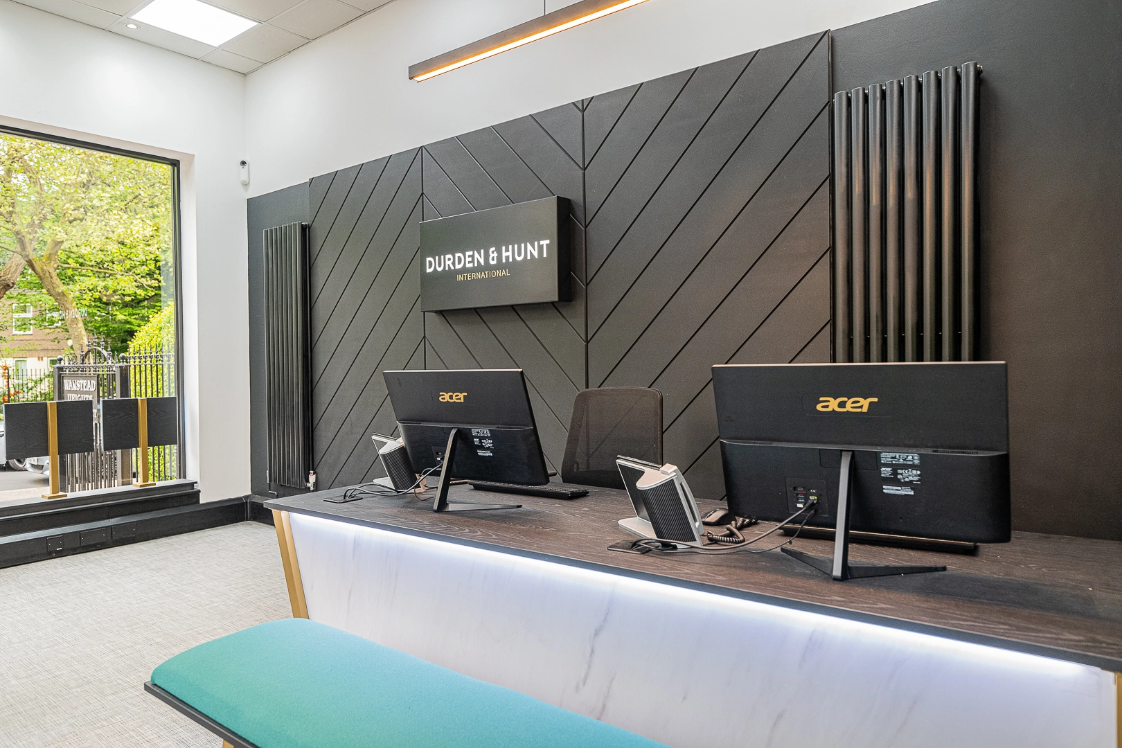 Durden & Hunt International office reception with desk, computer monitors, and dark geometric wall panelling
