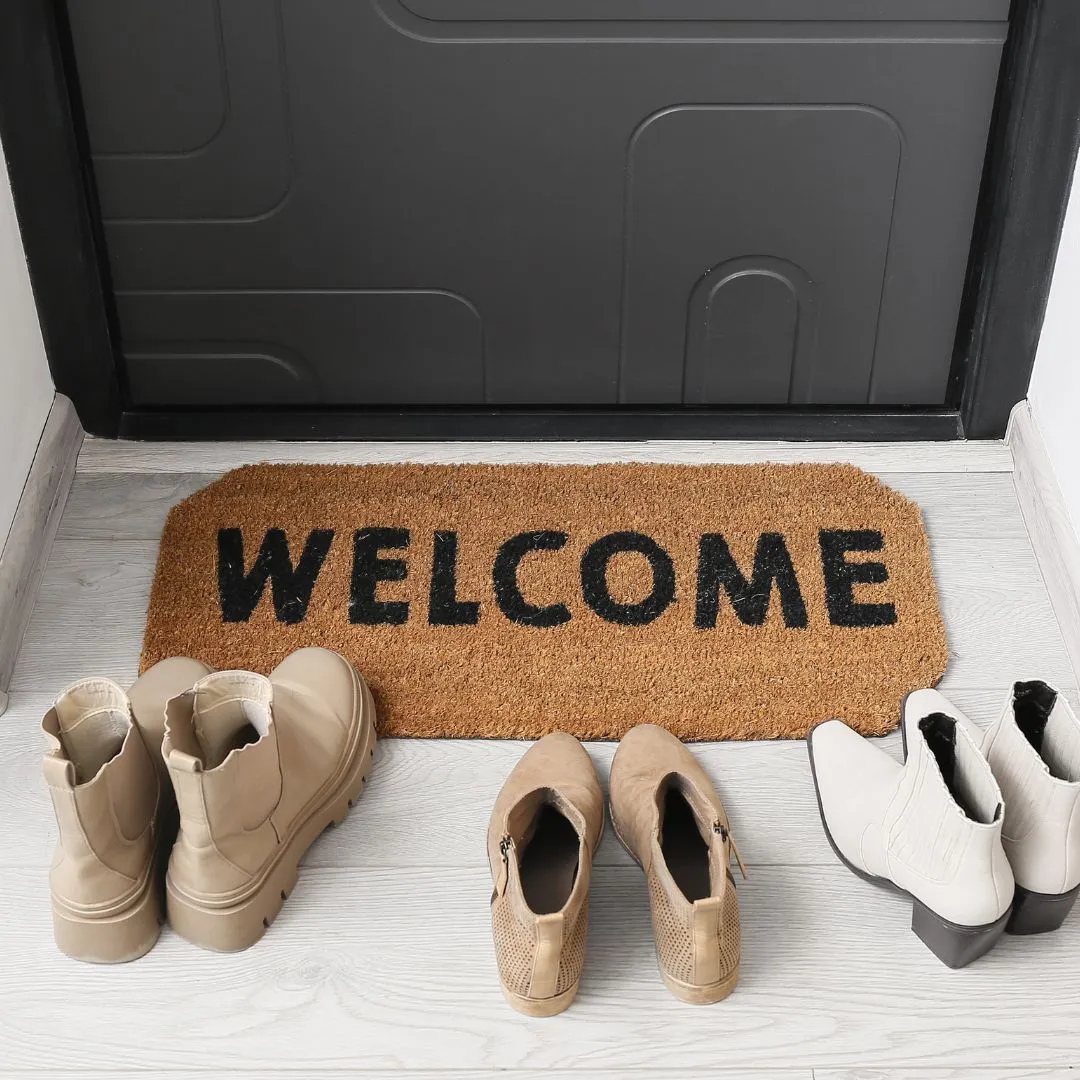 Welcome doormat at a front door with shoes neatly placed, creating a warm and inviting entrance for new tenants