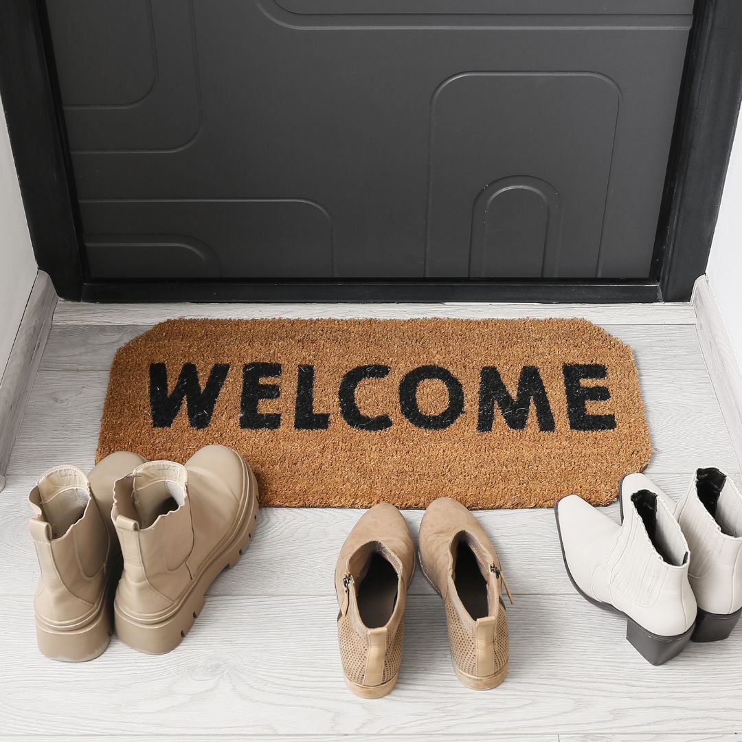 Welcome doormat at a front door with shoes neatly placed, creating a warm and inviting entrance for new tenants