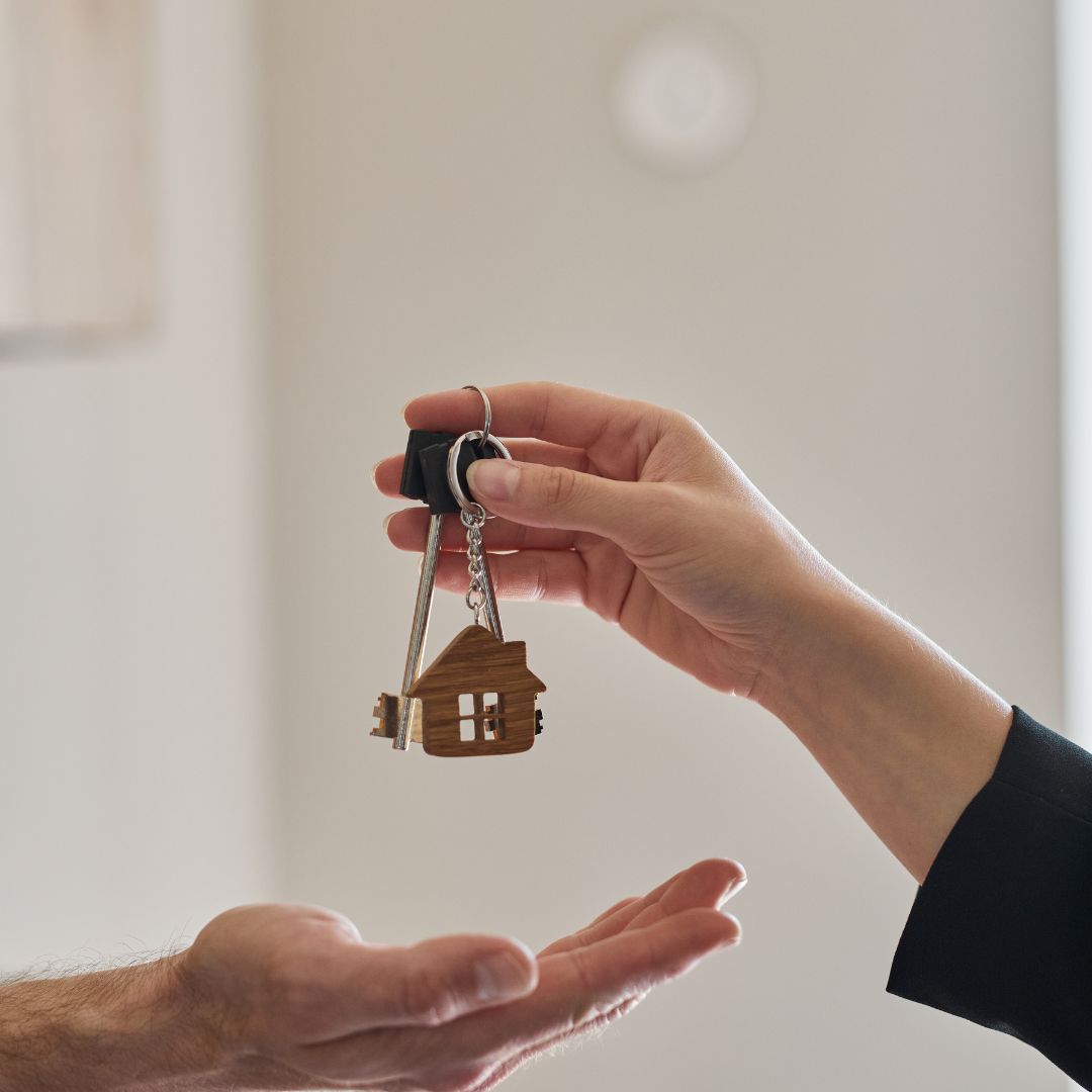 Handing over house keys to a new tenant, symbolising the start of a tenancy and property move-in