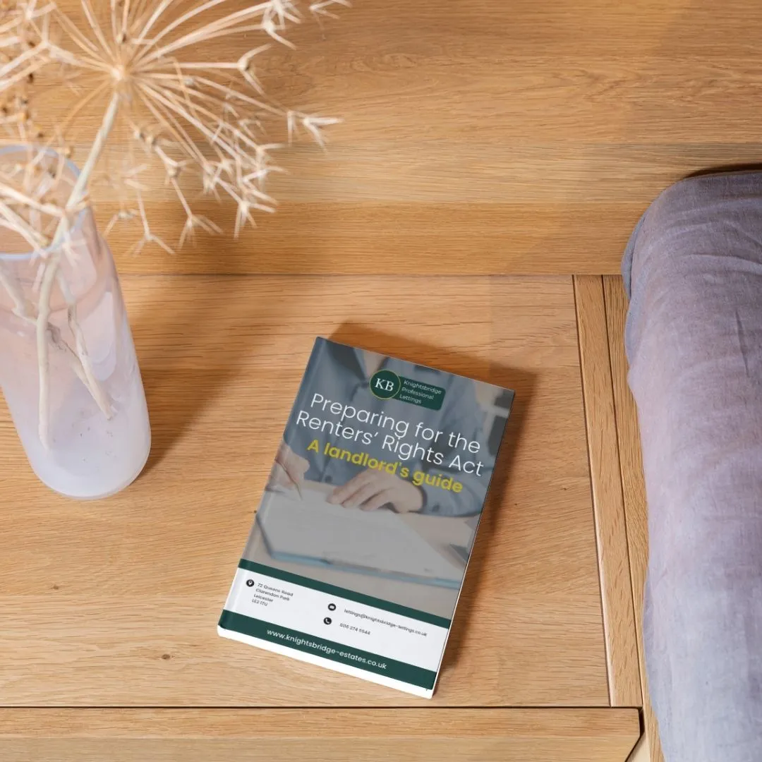 Booklet titled "Preparing for the Renters' Rights Act: A landlord's guide" on wooden table with white vase and purple cushion