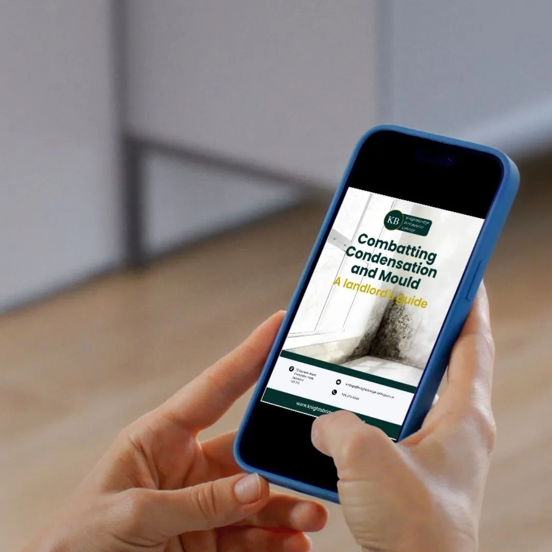 Hand holding blue phone displaying "Combatting Condensation and Mould: A landlord's guide" on screen, with blurred interior background