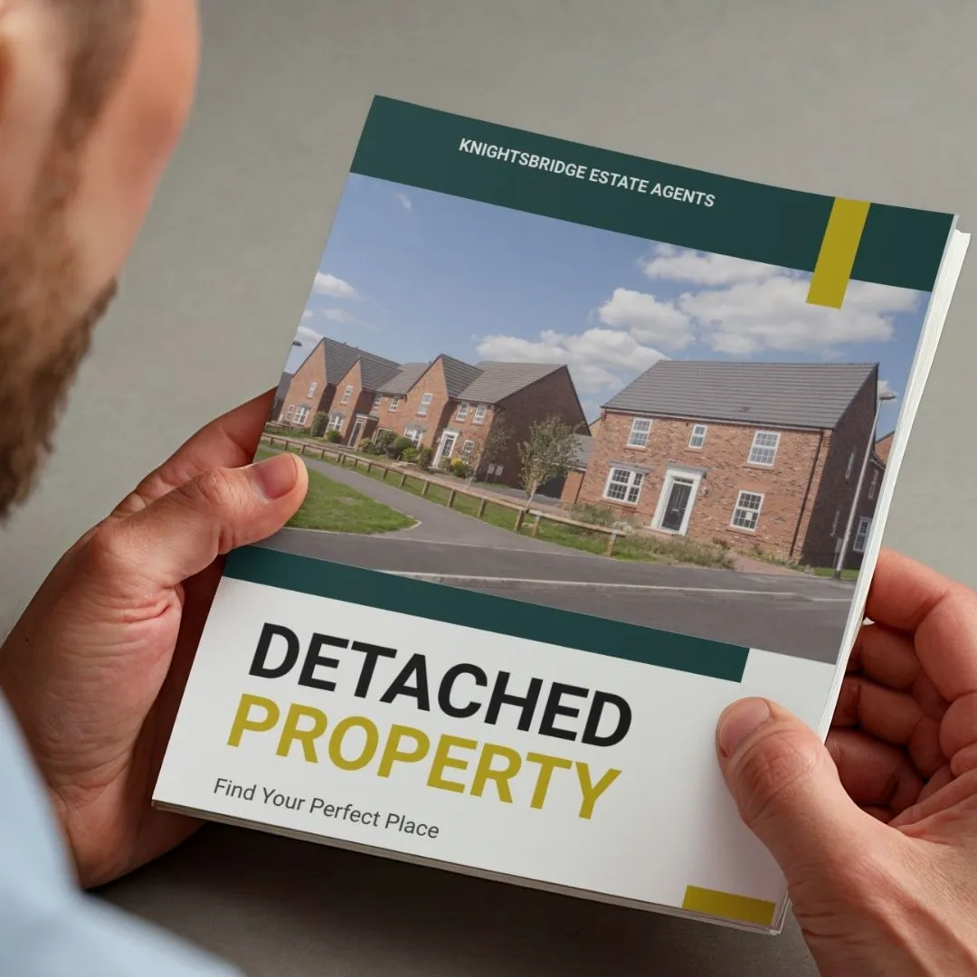 Hands holding Knightsbridge Estate Agents brochure showing detached brick houses and "Detached Property – Find Your Perfect Place" text