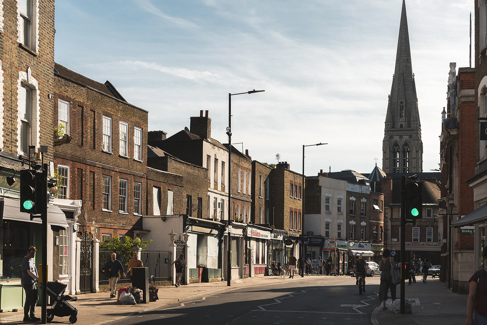 Church Street in Stoke Newington, lined with Victorian brick buildings, shops, and a church spire in the distance